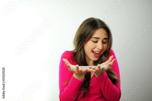 young woman girl playing pen in hand online learning reluctance to learn student life write dictation drawing pencil girl in a pink sweater on a white studio hold a pencil in the palm of your hand