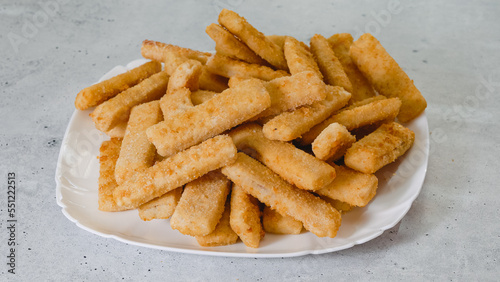Frozen breaded fish sticks close-up on a plate