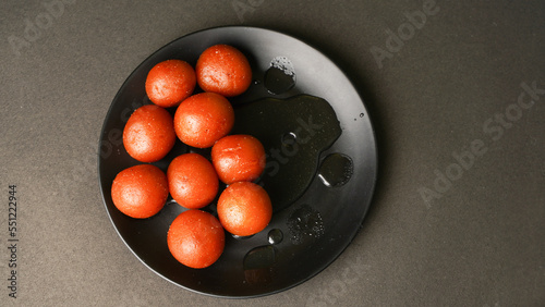 Fotografija Half eaten Sweet Gulab Jamun served in the plate, Famous Indian dessert sweets i