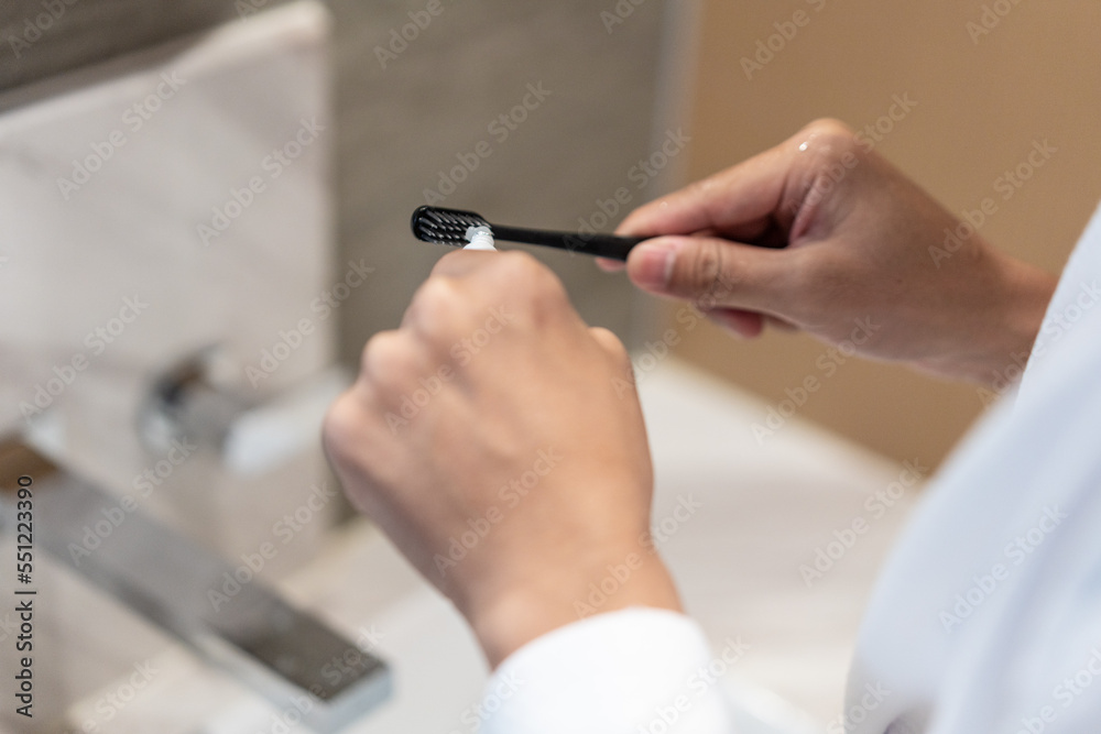 man is squeezing the toothpaste on the toothbrush. man is squeezing the toothpaste on the toothbrush.