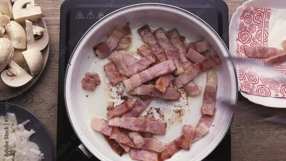 I fry the bacon in a frying pan in oil, cut into strips of slices I fry the bacon in a frying pan in oil, cut into strips of slices