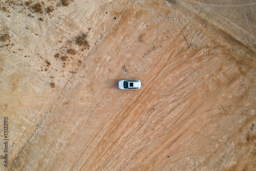 An overhead view of a vehicle in the middle of a desert landscape.