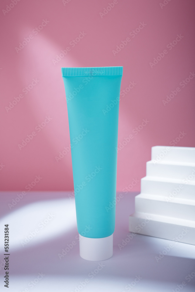 Turquoise tube of cream or tooth paste mockup template with blank label, no brand. Care cosmetics with concrete decor on pink backdrop Turquoise tube of cream or tooth paste mockup template with blank label, no brand. Care cosmetics with concrete decor on pink backdrop