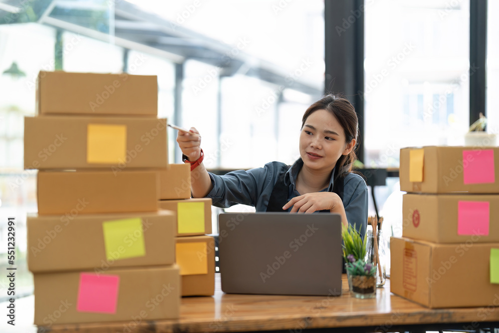 SME entrepreneur Small business entrepreneurs Online selling ideas, Happy Young Asian business owner work on computer and a boxes at home, delivery SME procurement package box deliver to customers SME entrepreneur Small business entrepreneurs Online selling ideas, Happy Young Asian business owner work on computer and a boxes at home, delivery SME procurement package box deliver to customers