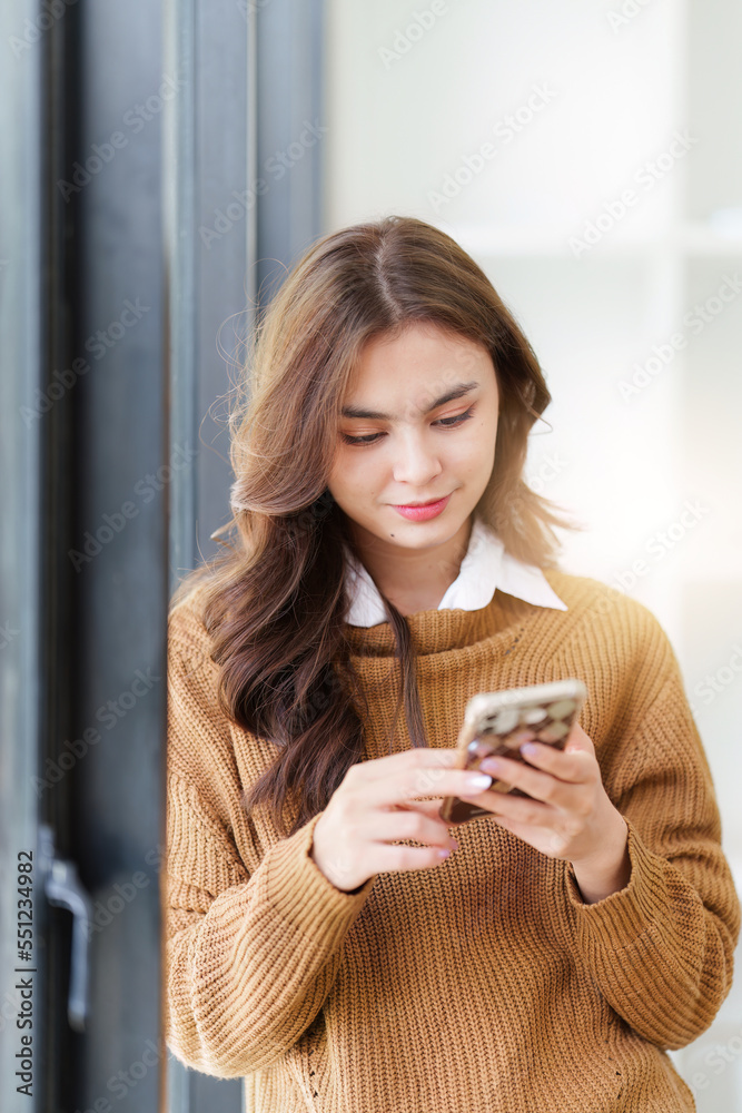 Young Asian Woman using smart phone at home. Female holding cellphone checking email or social media on internet Young Asian Woman using smart phone at home. Female holding cellphone checking email or social media on internet