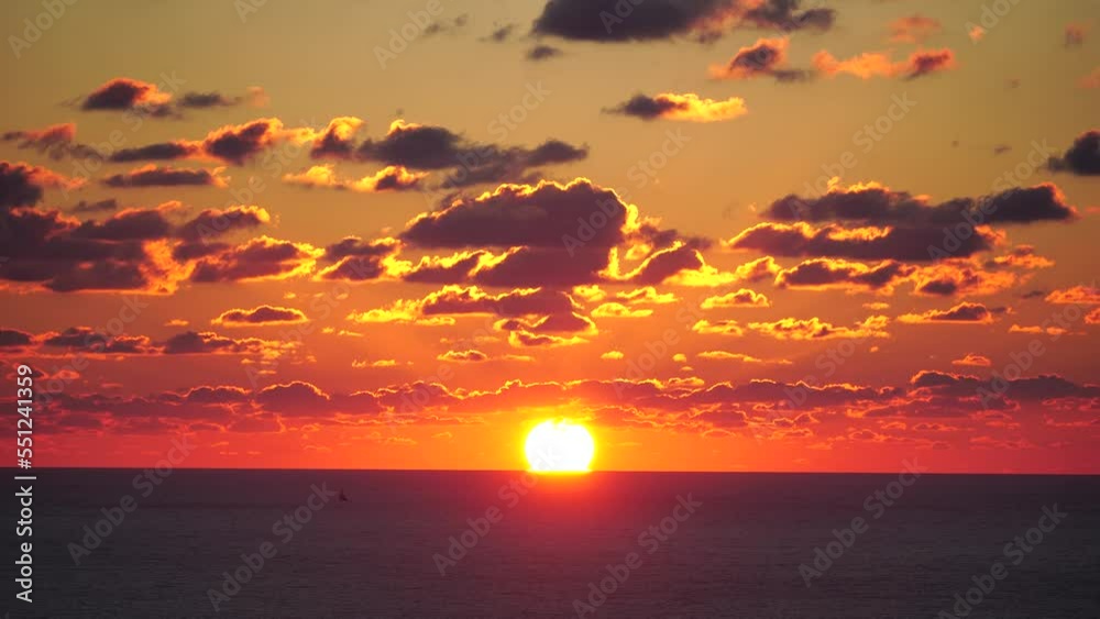 Timelapse. A red burning sunset over the sea. Abstract nature summer or spring ocean sea background. Small waves on golden warm water surface with bokeh lights from sun.