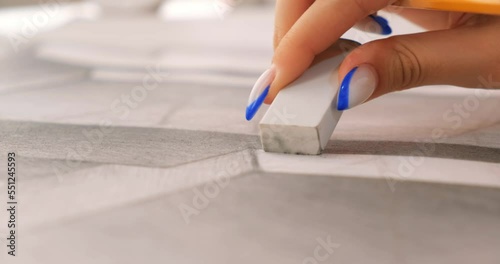 Girl corrects pencil drawing on paper with eraser, close-up. Captures creativity, fine art, and drawing lessons in 4K for art schools