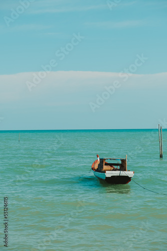 a fishing boat bobbing in the sea © Willy Chan