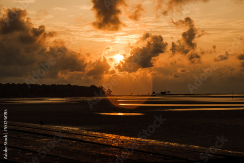 a sunrise view with flare and wood bridge foreground
