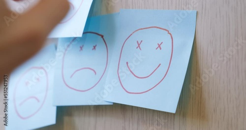 Man sticks a sticker with a funny face on the wall. The concept of good mood, positivity, luck, psychology, optimism and luck. 4K.