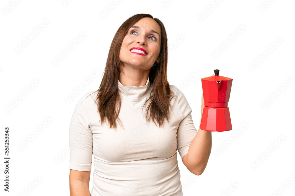 Middle-aged caucasian woman holding coffee pot over isolated background looking up while smiling Middle-aged caucasian woman holding coffee pot over isolated background looking up while smiling