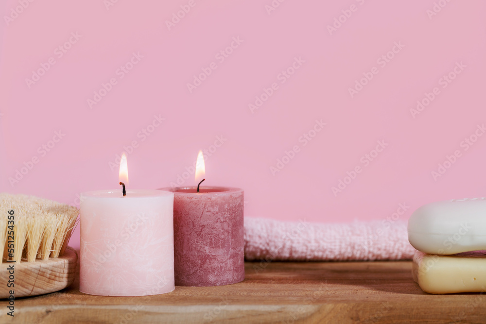Pink spa still life with candles, towel, body brush, soap and rose on wooden desk - ready for aromatherapy and bath Pink spa still life with candles, towel, body brush, soap and rose on wooden desk - ready for aromatherapy and bath
