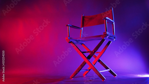 Black Director chair in red and blue light color with black background photo