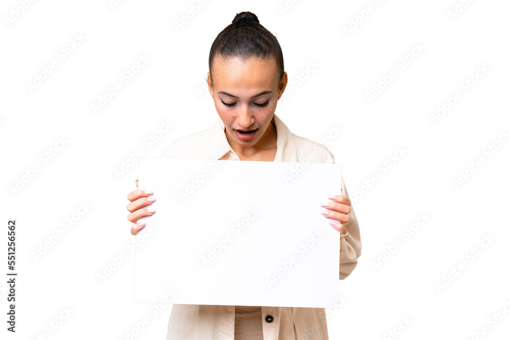 Young Arab woman over isolated background holding an empty placard and looking it Young Arab woman over isolated background holding an empty placard and looking it