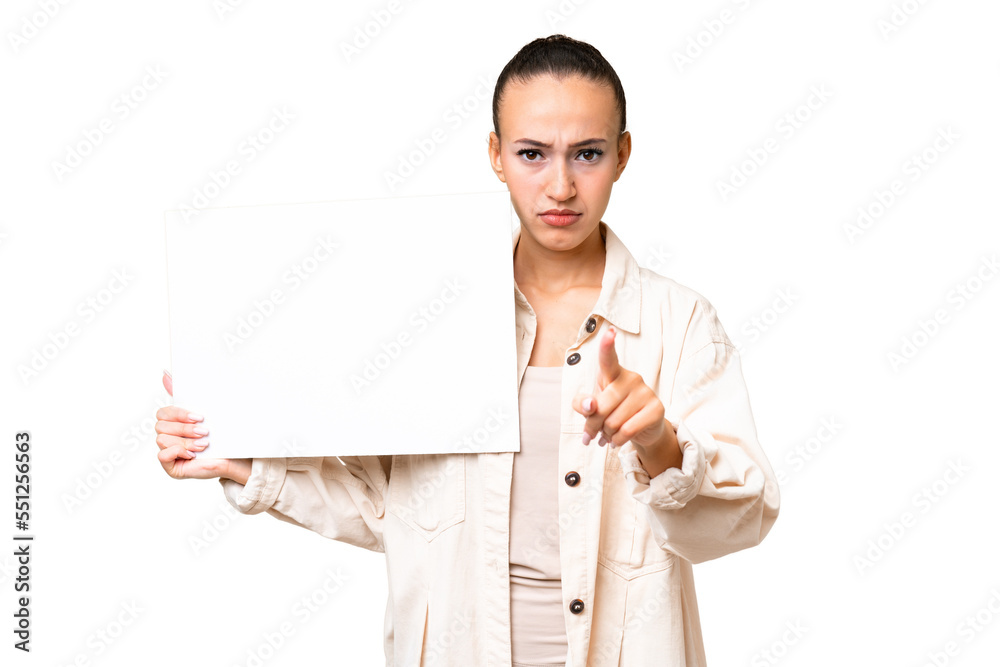 Young Arab woman over isolated background holding an empty placard and pointing to the front Young Arab woman over isolated background holding an empty placard and pointing to the front