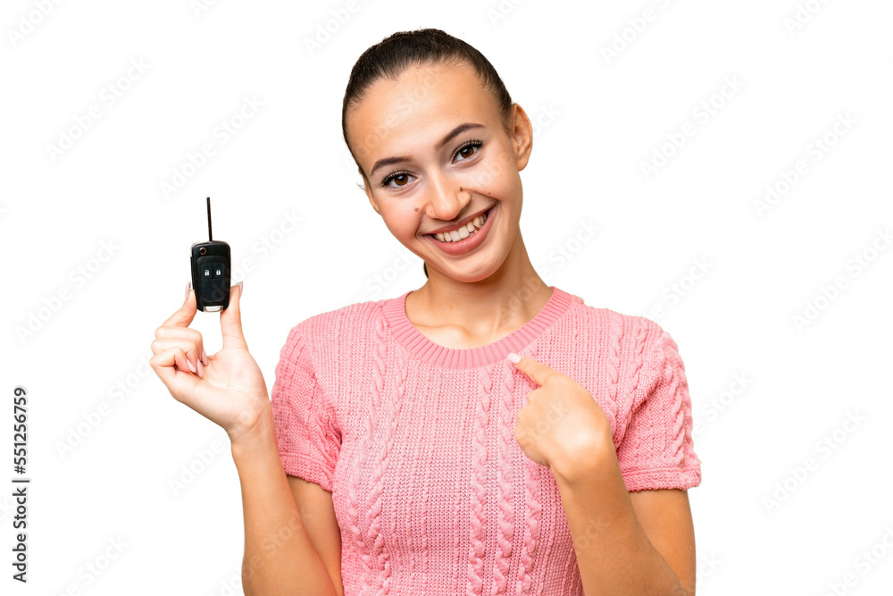 Young Arab woman holding car keys over isolated background with surprise facial expression Young Arab woman holding car keys over isolated background with surprise facial expression