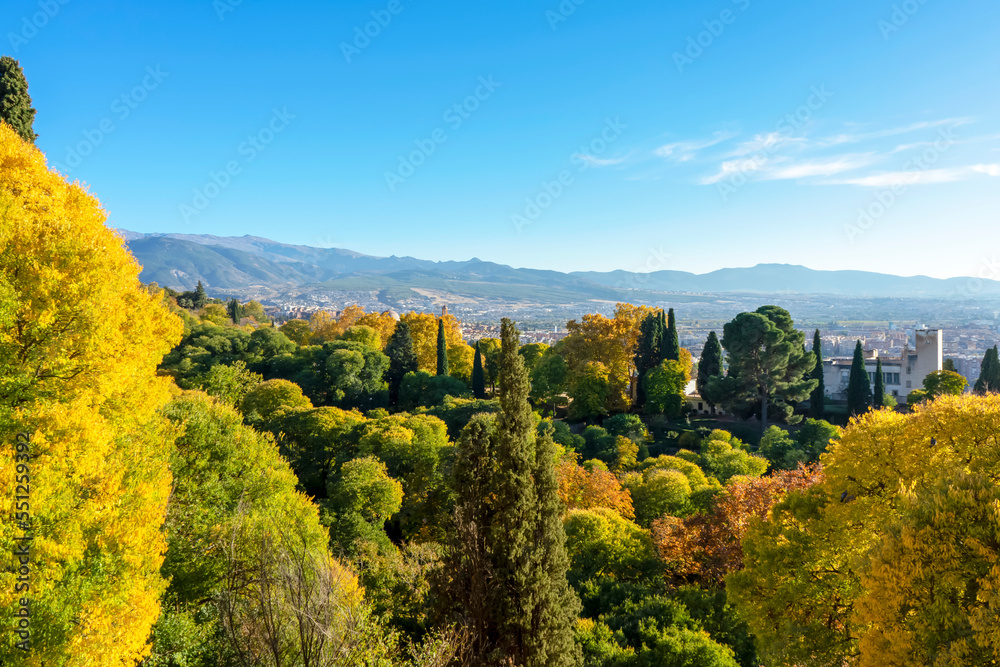 Green gardens of Alhambra on mountains peak covered by snow in Granada, Spain on November 26, 2022