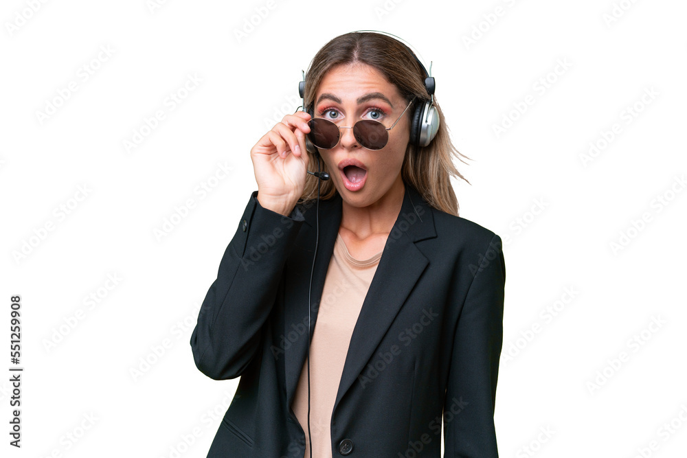 Telemarketer pretty Uruguayan woman working with a headset over isolated background with glasses and surprised Telemarketer pretty Uruguayan woman working with a headset over isolated background with glasses and surprised