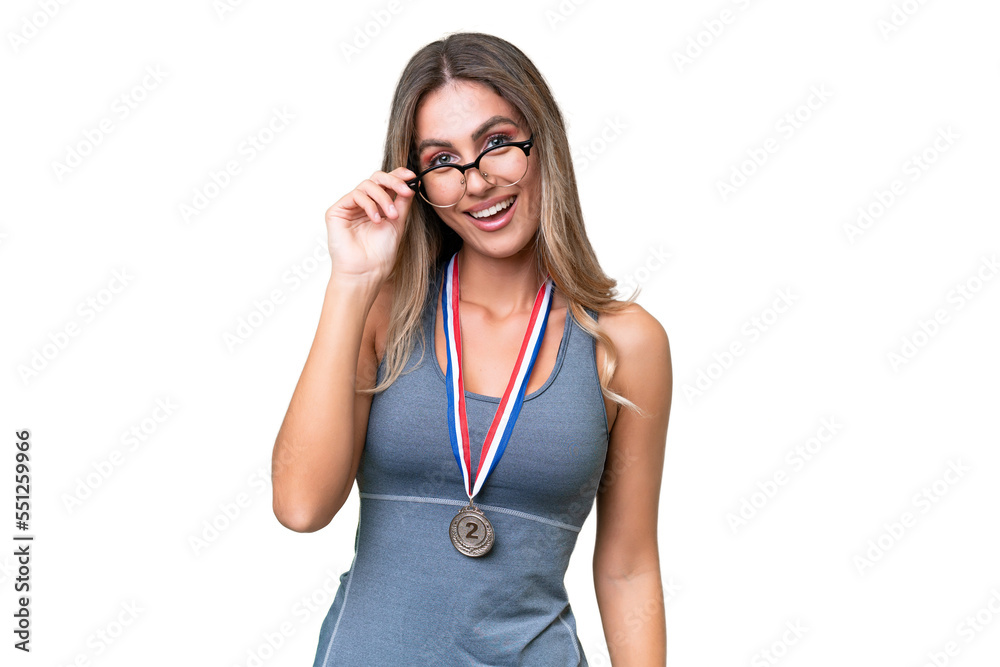 Young pretty sport Uruguayan woman with medals over isolated background with glasses and happy Young pretty sport Uruguayan woman with medals over isolated background with glasses and happy