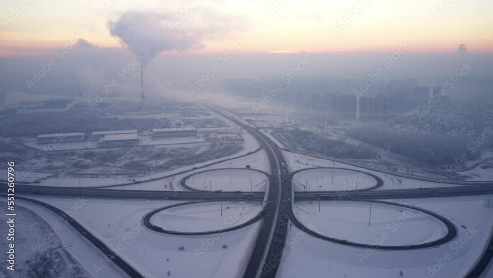 Traffic on road junction, winter season. Timelapse in motion. Aerial view. Snowy cold weather. Evening time