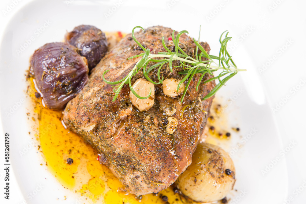 Roast pork loin with onions and garlic, decorated with rosemary and some colorful peppercorns Roast pork loin with onions and garlic, decorated with rosemary and some colorful peppercorns