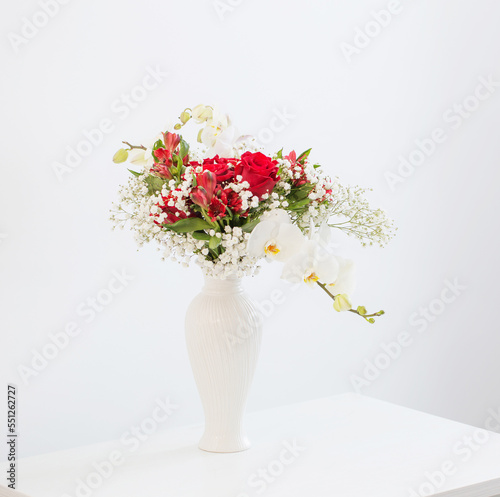 red and white bouquet in vase on white background