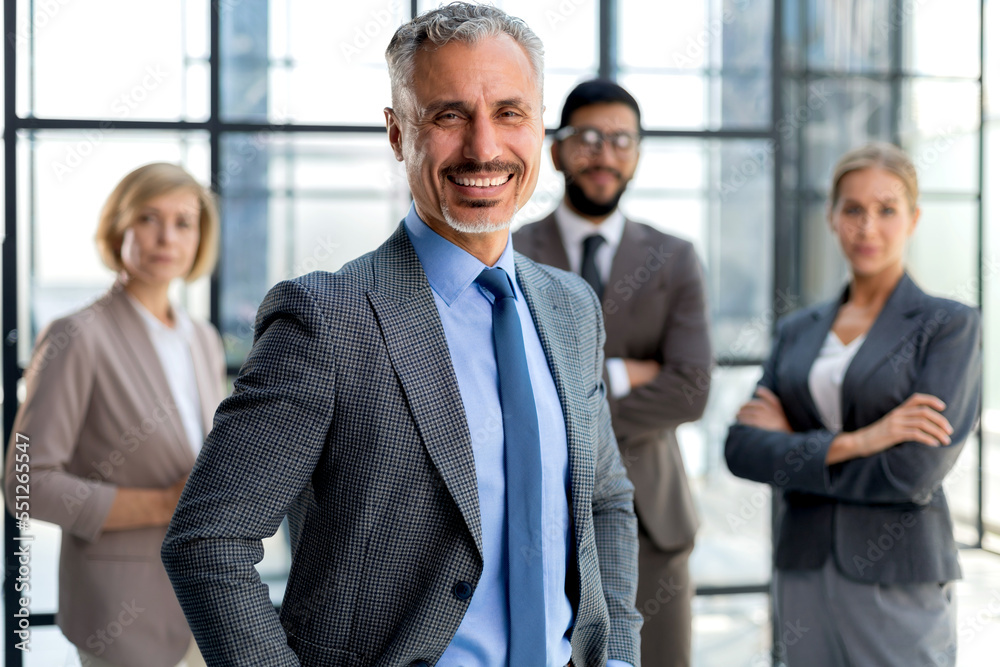 Businessman with colleagues in the background in office. Businessman with colleagues in the background in office.