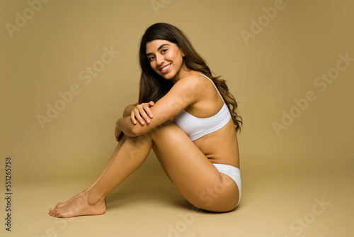 Smiling woman relaxing in her white underwear