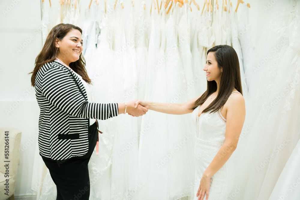 Business owner of a bridal shop meeting a customer buying her wedding gown