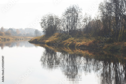 Autumn landscape with colorful trees reflected in the water.