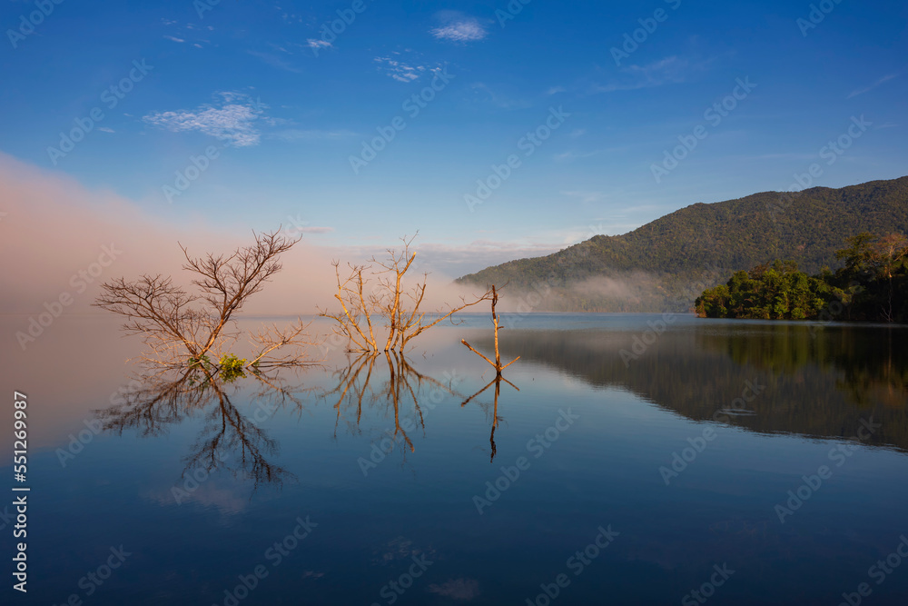 The water reflection of the sunrise breathtaking beauty nature scenery landscape with mountain mist in Khuean Phluang Reservoir nearby Khao Khitchakut National Park, Chanthaburi, Thailand

