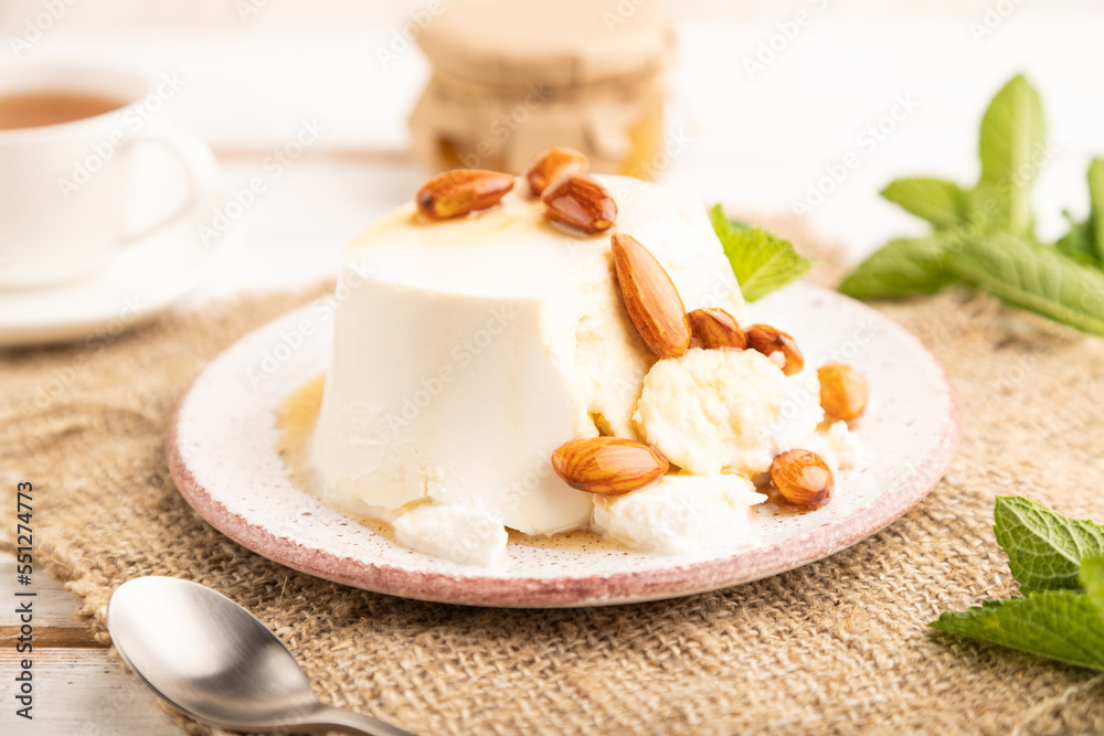 Ricotta cheese with honey and almonds on white wooden. side view, selective focus. Ricotta cheese with honey and almonds on white wooden. side view, selective focus.