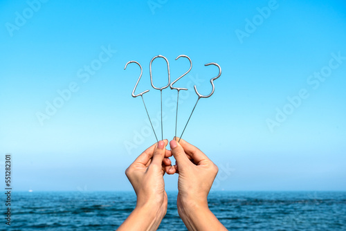 happy new year 2022 background. The numbers of the coming year in the hands of a young girl on sea