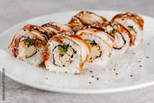 Eight servings of shrimp and eel sushi on a white plate.