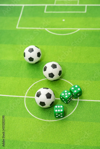 dice and soccer ball on green grass, football sports betting concept