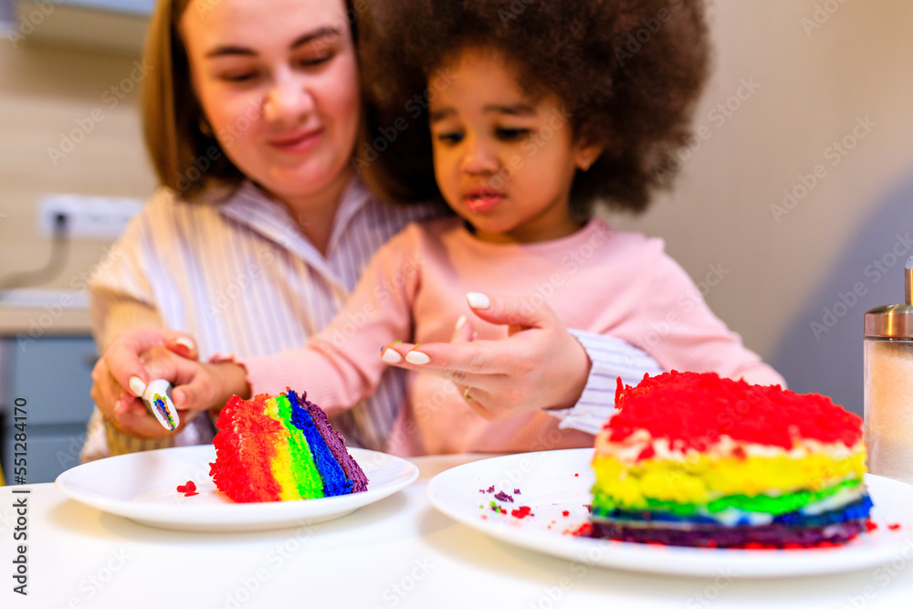happy multiethnic family eating rainbow cake at kitchen happy multiethnic family eating rainbow cake at kitchen