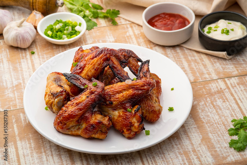 Air Fryer grilled chicken wings on white plate,served with ketchup and mayonnaise