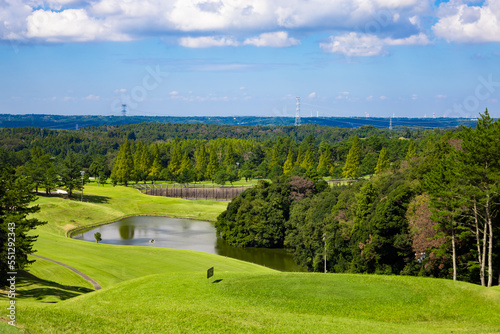 青空のゴルフ場・池や多数のコブがある打ち下ろしで難しいコースの眺め（千葉県木更津市） 