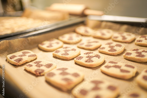 Freshly baken cookies with a chessboard pattern on a baking plate.  photo