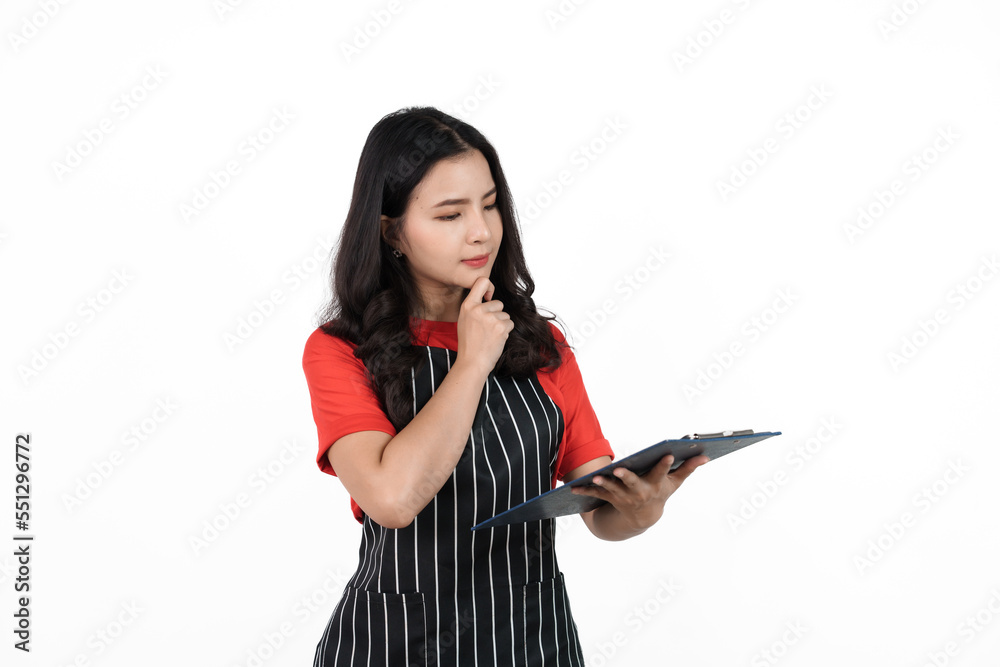Holding clipboard, Food shop owner concept, Smiling young confident asian woman in black apron and red t-shirt isolated on white background. Holding clipboard, Food shop owner concept, Smiling young confident asian woman in black apron and red t-shirt isolated on white background.