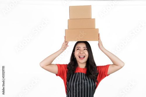 Holding package box, Food shop owner concept, Smiling young confident asian woman in black apron and red t-shirt isolated on white background.
