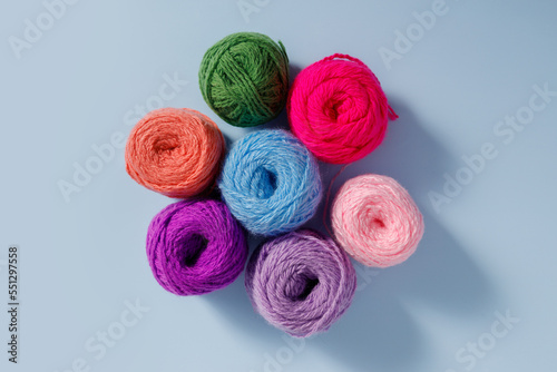 Skeins of multi-colored woolen threads isolated on a blue background. photo