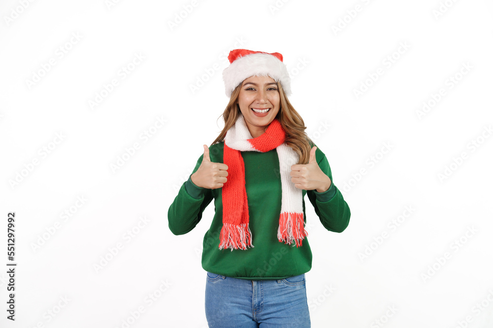 Attractive excited asian female in green sweater with santa hat on christmas isolated on white background. Thumb up Attractive excited asian female in green sweater with santa hat on christmas isolated on white background. Thumb up
