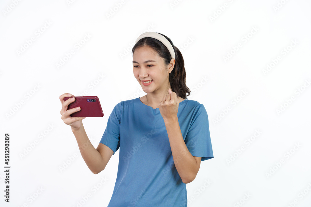 Beautiful Asian woman in blue t-shirt isolated on white background. Holding cellphone Beautiful Asian woman in blue t-shirt isolated on white background. Holding cellphone