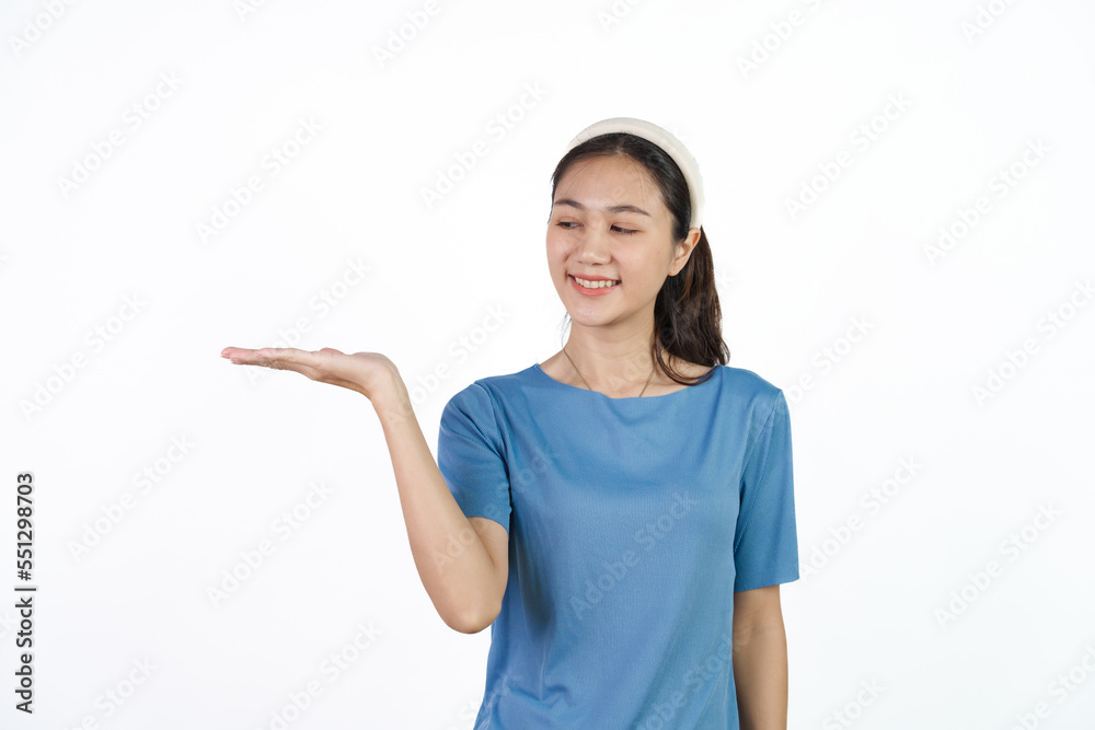 Beautiful Asian woman in blue t-shirt isolated on white background. Palm up Beautiful Asian woman in blue t-shirt isolated on white background. Palm up