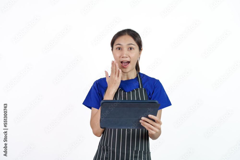 Excited asian coffee shop SME owner asian woman wearing blue t-shirt and black apron isolated on white background. Holding and using tablet Excited asian coffee shop SME owner asian woman wearing blue t-shirt and black apron isolated on white background. Holding and using tablet