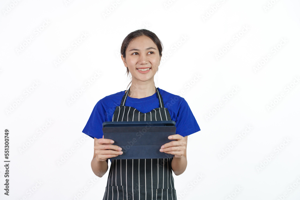 Excited asian coffee shop SME owner asian woman wearing blue t-shirt and black apron isolated on white background. Holding and using tablet Excited asian coffee shop SME owner asian woman wearing blue t-shirt and black apron isolated on white background. Holding and using tablet