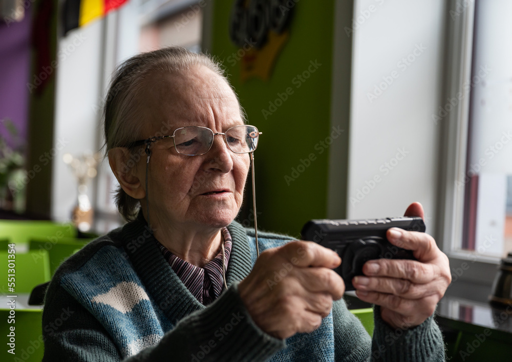 84 yo white grandmother making a photo with a smartphone at home, Belgium 84 yo white grandmother making a photo with a smartphone at home, Belgium