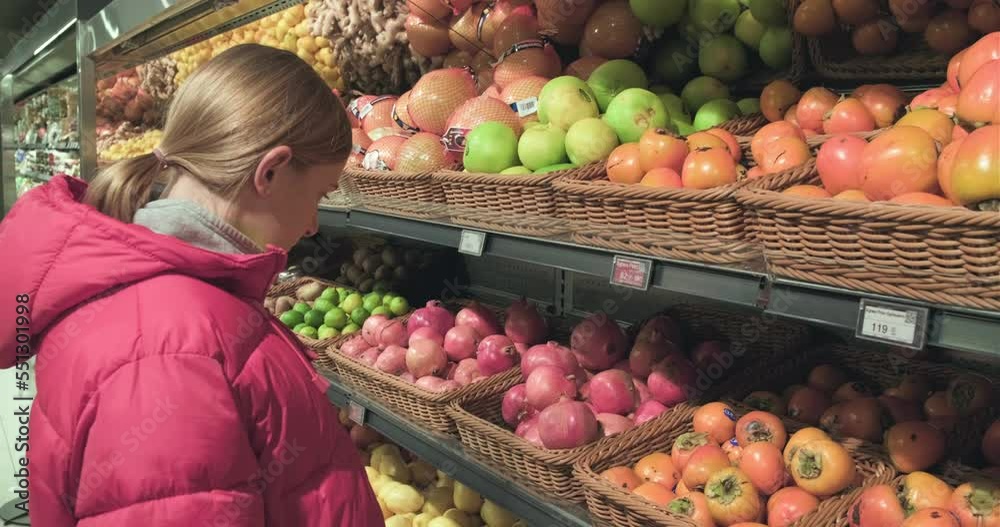 Kyiv, Ukraine, December 2022: a woman chooses a products on the shelves of a supermarket Kyiv, Ukraine, December 2022: a woman chooses a products on the shelves of a supermarket