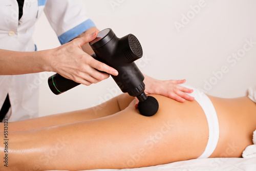 The massage therapist gives the patient anti-cellulite massage with a massage tool